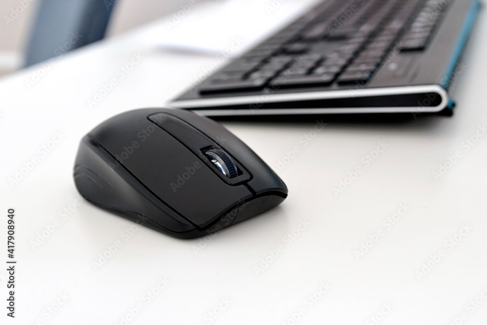 Closeup of black computer mouse on the office table. Selective focus. Closeup of black computer mouse on the office table. Selective focus.