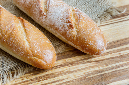 Fresh baguette bread on wooden background