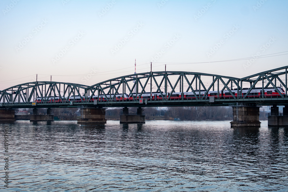 Railway bridge over the Danube River in Vienna, Austria during sunset