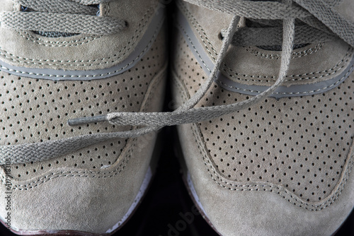 Fragment of gray men's leather sneakers, close-up.
