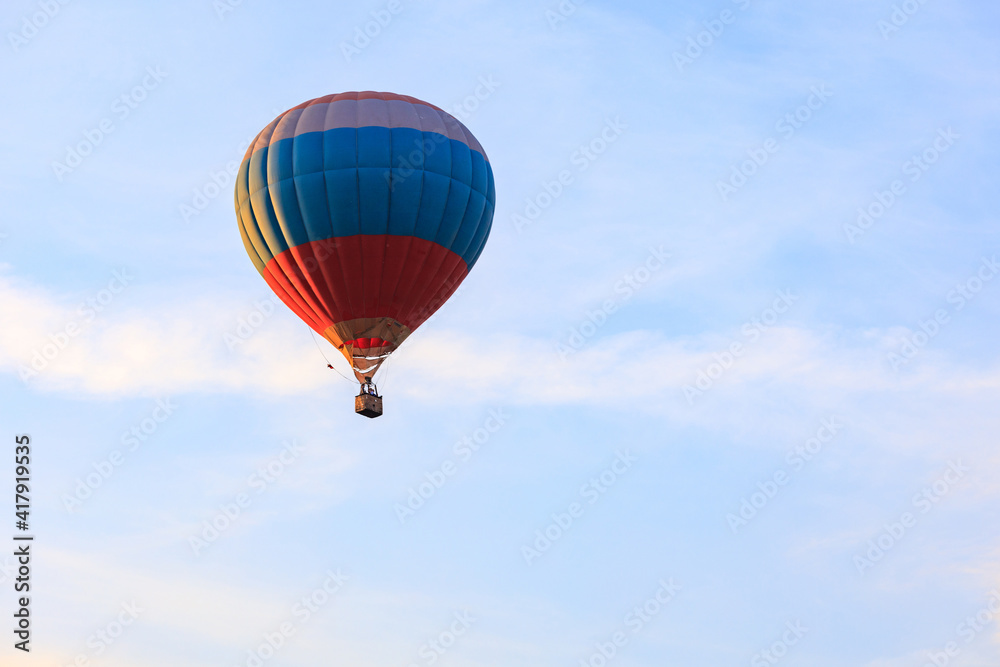 Obraz premium tricolor hot air balloon in the sky with clouds