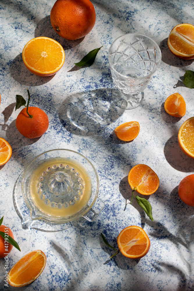 oranges and clementines vitamin juice on light blue table