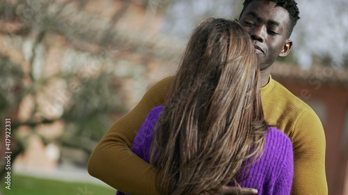 Interracial couple love and embrace. Black man hugs girlfriend, close-up hands back