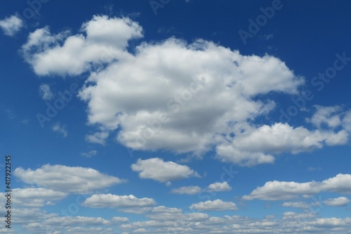 Blue sky with beautiful fluffy cumulus clouds, natural background 