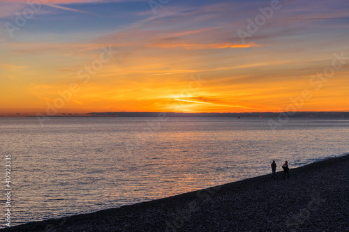 Beautiful sunset on the beach in Sochi, in Adler in spring. Silhouettes of people on the beach