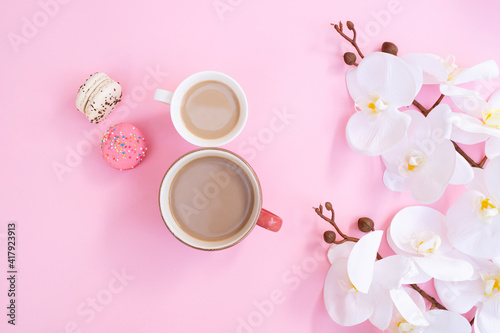 Women day 8 March concept. Morning coffee, macarons and white orchid flowers on pink pastel background. Flat lay. orkide