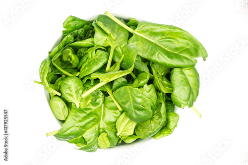 Young spinach in bowl isolated on white background top view