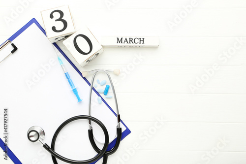 Wallpaper Mural Stethoscope with clipboard, cube calendar and pills on white wooden table Torontodigital.ca