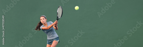Tennis player playing game on outdoor hard court banner. Athlete Asian woman hitting ball with racket during match panoramic header. on green banner. Sports in competition. © Maridav