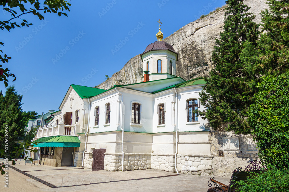 Fototapeta premium Trinity Church in Inkerman cave monastery complex. It was built in 1850 nearby site of ancient Byzantine church (founded in 8 AD). Caves in rocks behind used as monk cells. Shot in Inkerman, Crimea