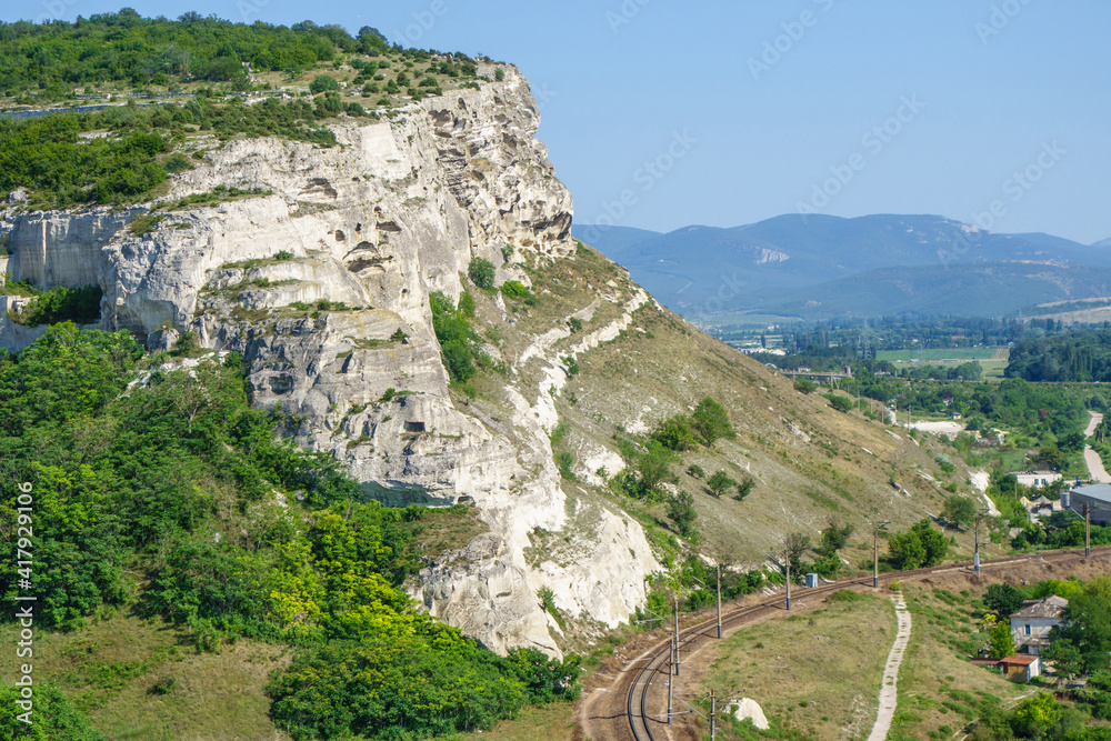 Panorama of landscape near Inkerman, Crimea. There are classic white chalk mountains with plateau on top, railroad and blue hills on background. Shot from Monastery hill near Cave Church of St Clement