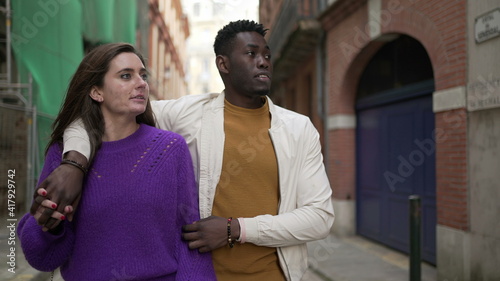 Young interracial couple walking together, modern millennial boyfriend and girlfriend in street