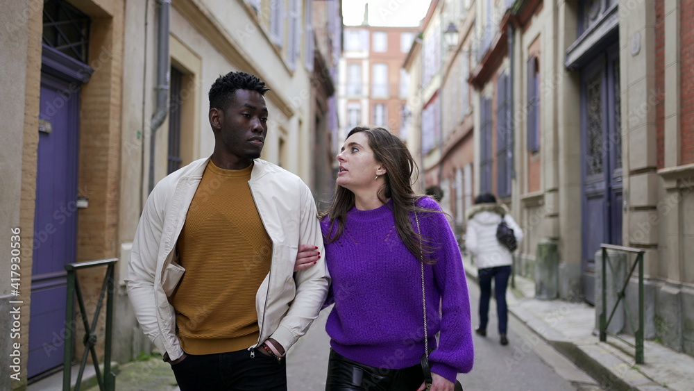 Young romantic interracial couple walking outside in european city