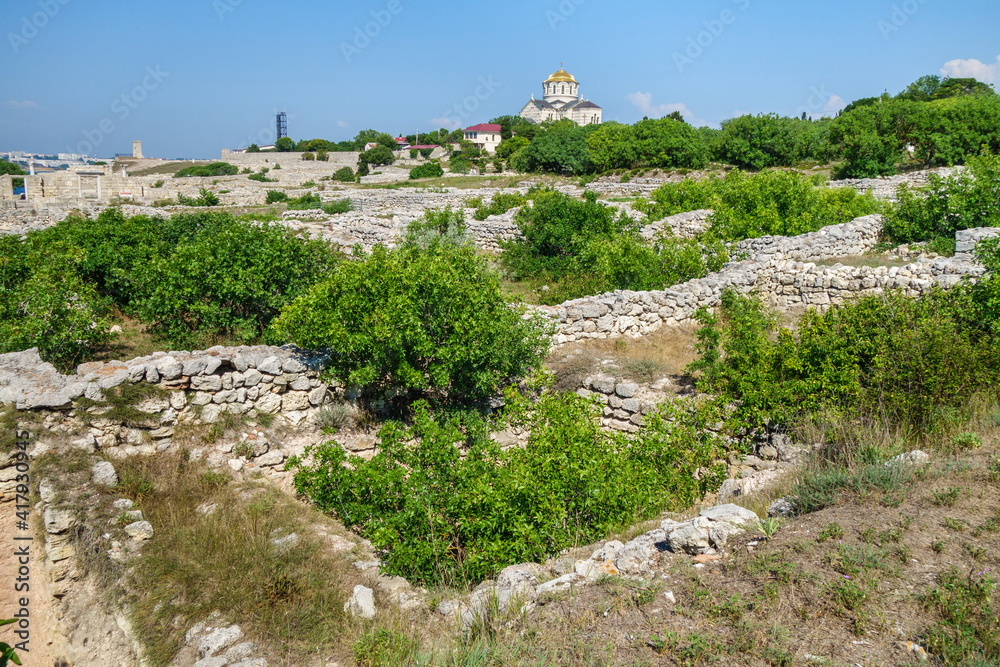 Remains of residential houses in ancient city Chersonesus, Sevastopol, Crimea. City founded in V BC by Greeks. Now this is open air museum and archaeological site. Vladimir Cathedral is on background