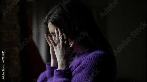 Young woman standing by window having a headache. Anxious concerned emotion © Marco
