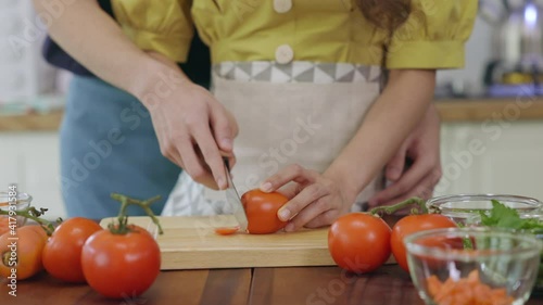 A lovely couple Are helping to prepare ingredients for cooking In a romantic atmosphere in the kitchen at home.