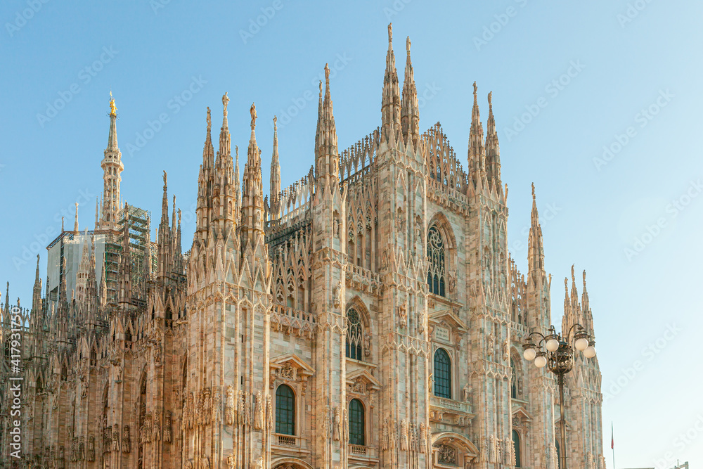 Famous church Milan Cathedral Duomo di Milano with Gothic spires and white marble statues. Top tourist attraction on piazza in Milan Lombardia Italy Wide angle view of old Gothic architecture and art