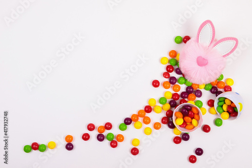 Fototapeta Naklejka Na Ścianę i Meble -  Easter concept, candy pills, egg, pink bunny head toy on white background. Place for text