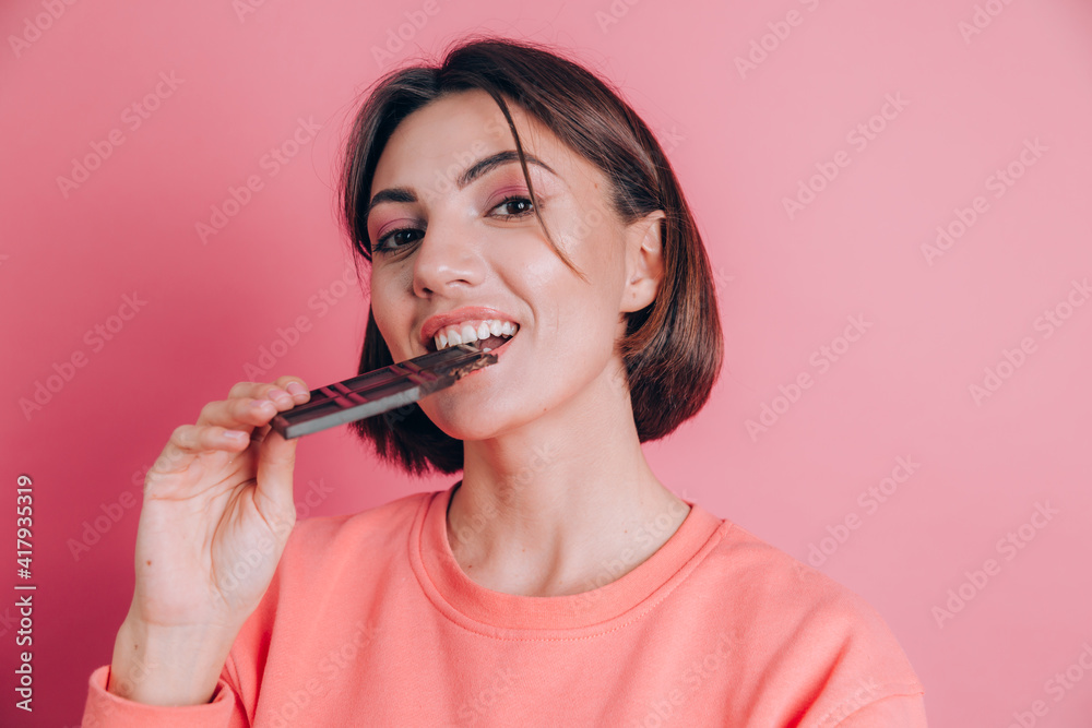 Beautiful young happy woman with chocolate bar on pink background and bright makeup Beautiful young happy woman with chocolate bar on pink background and bright makeup