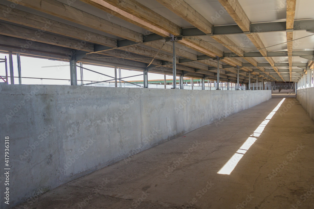 The roof structure of a large hangar consists of a steel frame and timber floor joists. Construction phase of a large complex on a farm The roof structure of a large hangar consists of a steel frame and timber floor joists. Construction phase of a large complex on a farm