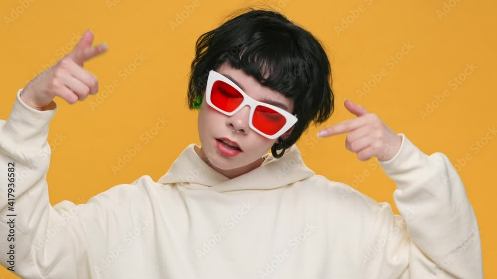 Surprised Teenager Girl Showing Emotion Think About it!, Really? Gesture with Index Finger to Temple of Head in Red Sunglasses on Yellow Background. Fashion. Monotone. Emotions People. Lifestyle. Surprised Teenager Girl Showing Emotion Think About it!, Really? Gesture with Index Finger to Temple of Head in Red Sunglasses on Yellow Background. Fashion. Monotone. Emotions People. Lifestyle.