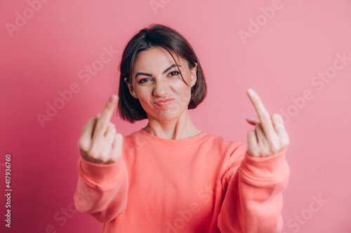 Woman wearing casual sweater on background showing middle finger doing bad expression, provocation and rude attitude