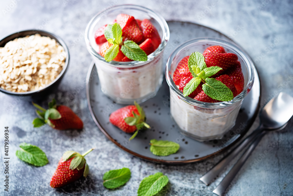 Oatmeal porridge with milk and fresh strawberries in a glass Oatmeal porridge with milk and fresh strawberries in a glass