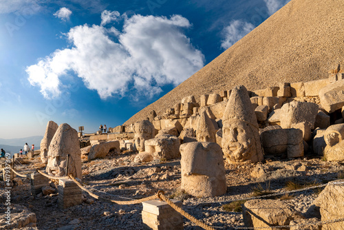 Kahta, Adiyaman, Turkey - September 14 2020: Commagene statue ruins on top of Nemrut Mountain with blue sky. Stone heads at the top of 2150 meters high Mount Nemrut. photo