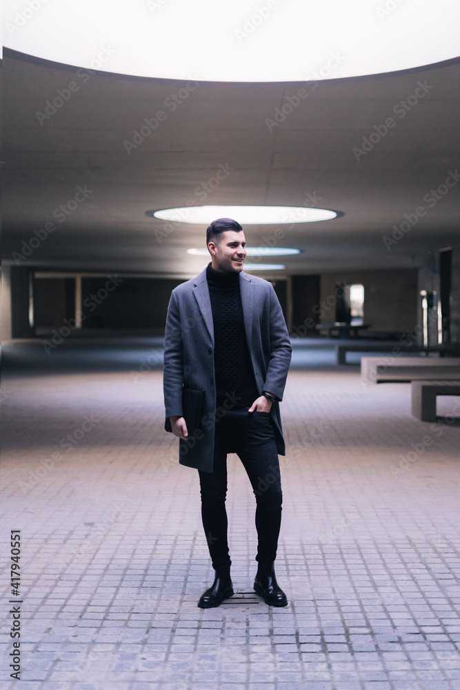 Fototapeta premium Handsome businessman standing with a laptop