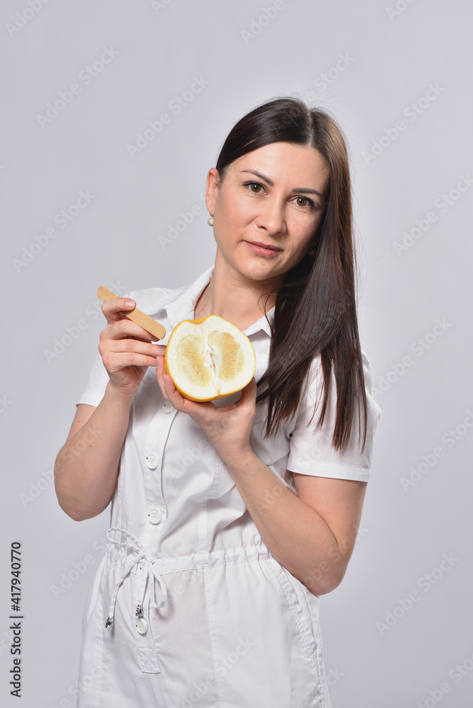 Depilation master holding grapefruit in hands, concept of female intimate depilation