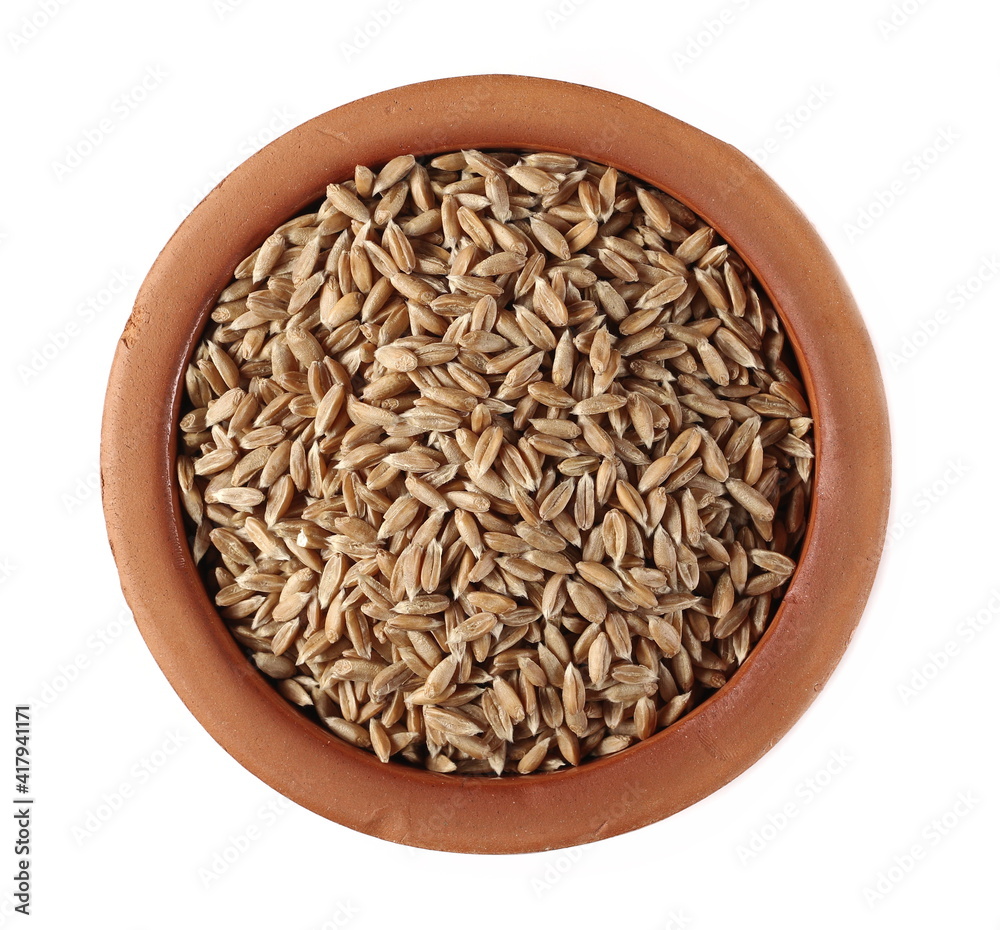 Spelt grain in clay pot isolated on white background, top view
