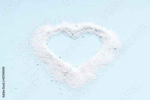 washing powder heap isolated on blue background. washing detergent cut out. heart symbol