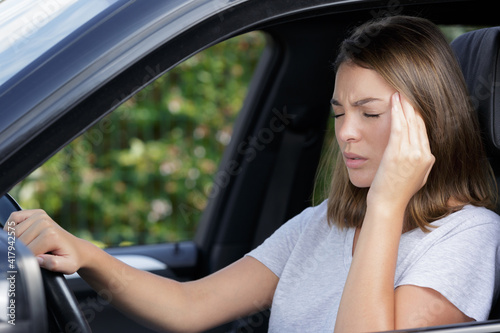 young woman suffering with headache in the car © auremar
