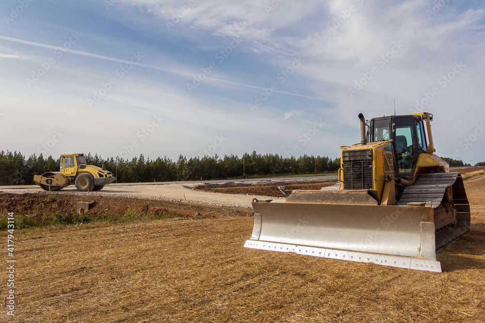 Fototapeta premium Road Roller and Bulldozer on the construction of a new road. Construction machinery. Dedicated Construction machinery for handling bulk materials