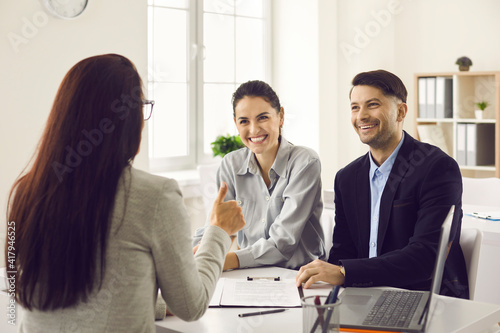 Obraz na płótnie Bank manager offers excellent option and gives thumbs up talking to happy clients in consultation meeting