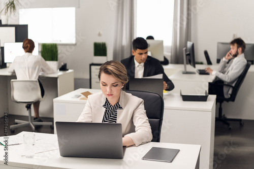 Customer service Manager at the workplace at the table with a laptop