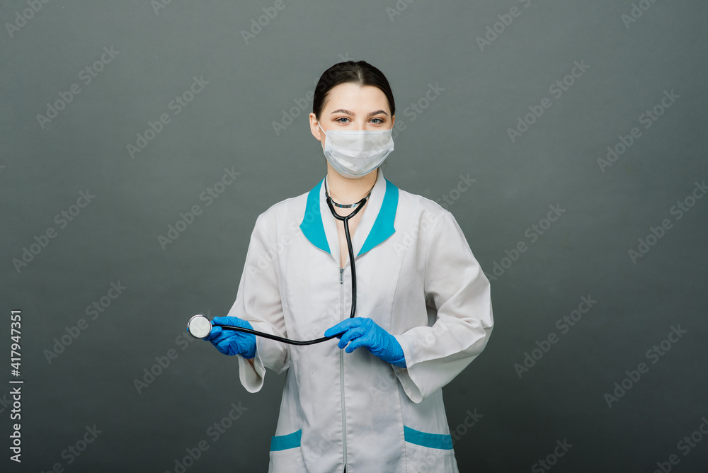 Cheerful happy doctor with crossed hands on grey background Cheerful happy doctor with crossed hands on grey background