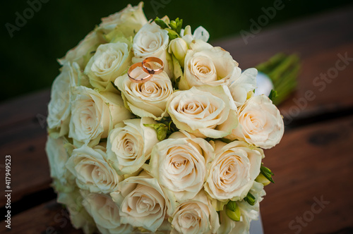 Wedding gold rings on a bouquet with white roses