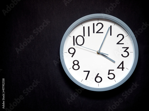 white round analog clock on black background