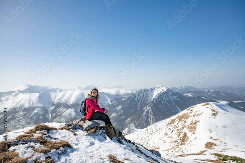 Young woman in snowy mountains in winter. Mountain tourism.