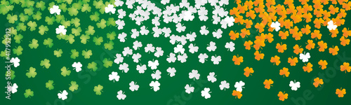 Irish flag with falling green white orange clovers Happy St Patricks Day background banner