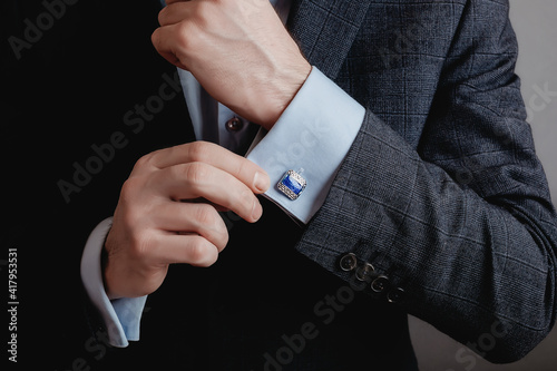Close up of businessman wearing cufflinks. Elegant young fashion business man wearing suit.