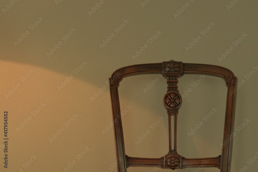 zoom in Backrest of a antique mahogany chair. 

This expensive furniture is made in England. 
dim lighting room soft focus image. 