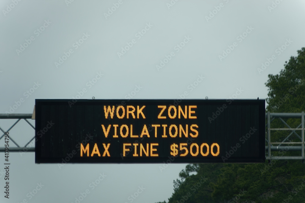 Overhead sign warning drivers to slow down in a construction zone.