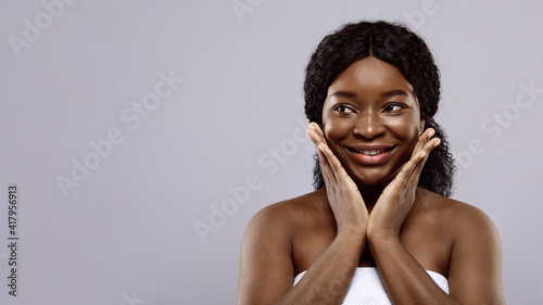 Portrait Of Cute African Woman Wrapped In Towel Looking Aside With Excitement