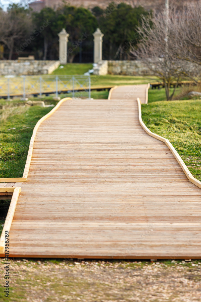 A walkway made of wooden planks in a city park.