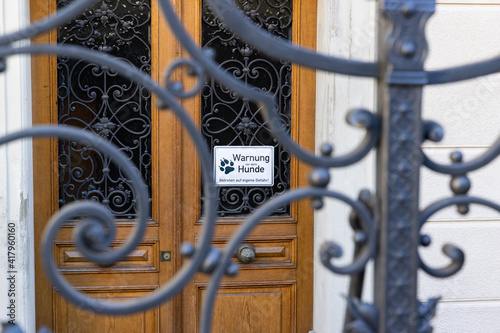 Valokuva lattice door in foreground, brown wooden door in background with german text sig