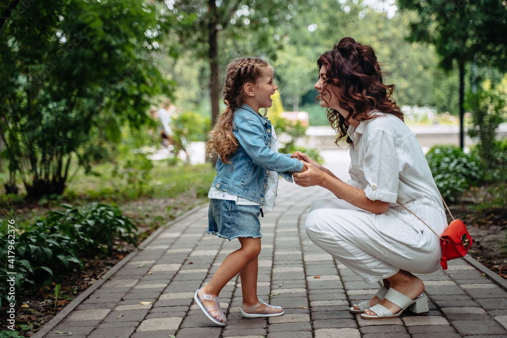 Lovely young mom and daughter in sunny day, happy family