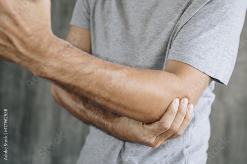 Close up of man suffering from pain in hand or elbow