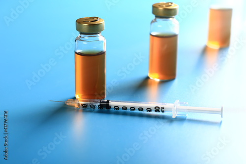 vaccine vials on a blue background. medical concept. Very shallow depth of field. illumination across the frame